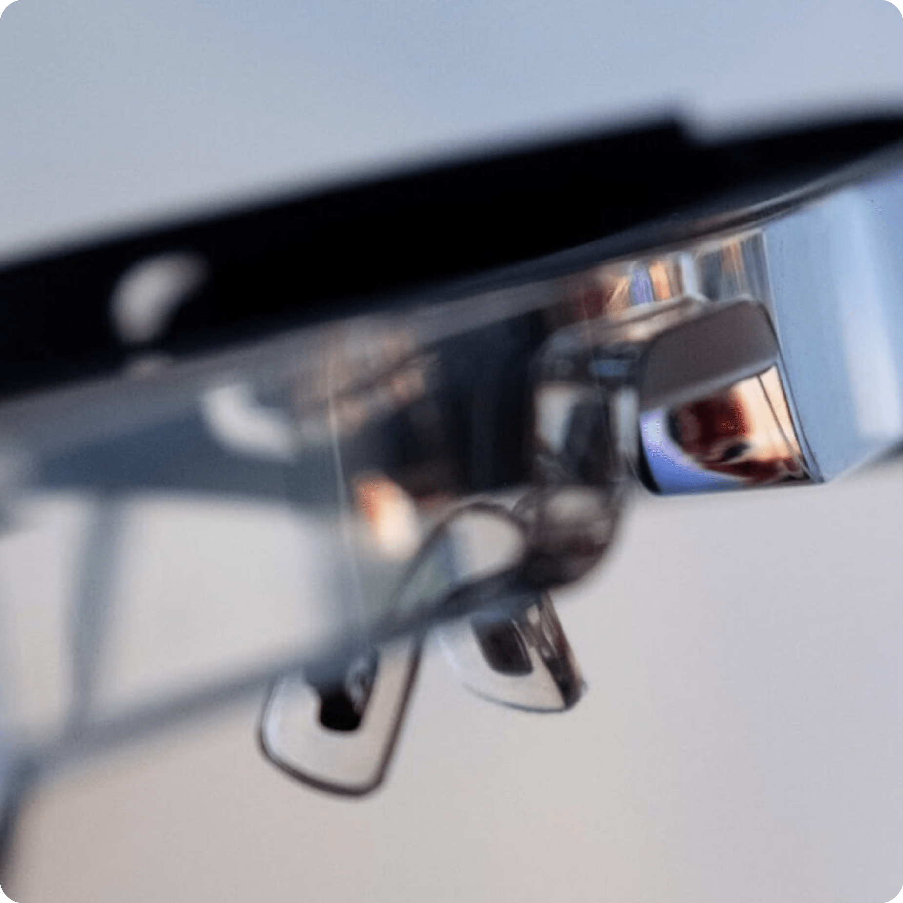 Close-up of the nose pads and lens of a pair of eyeglasses with a blurred background, showing reflective surfaces and clear plastic details.