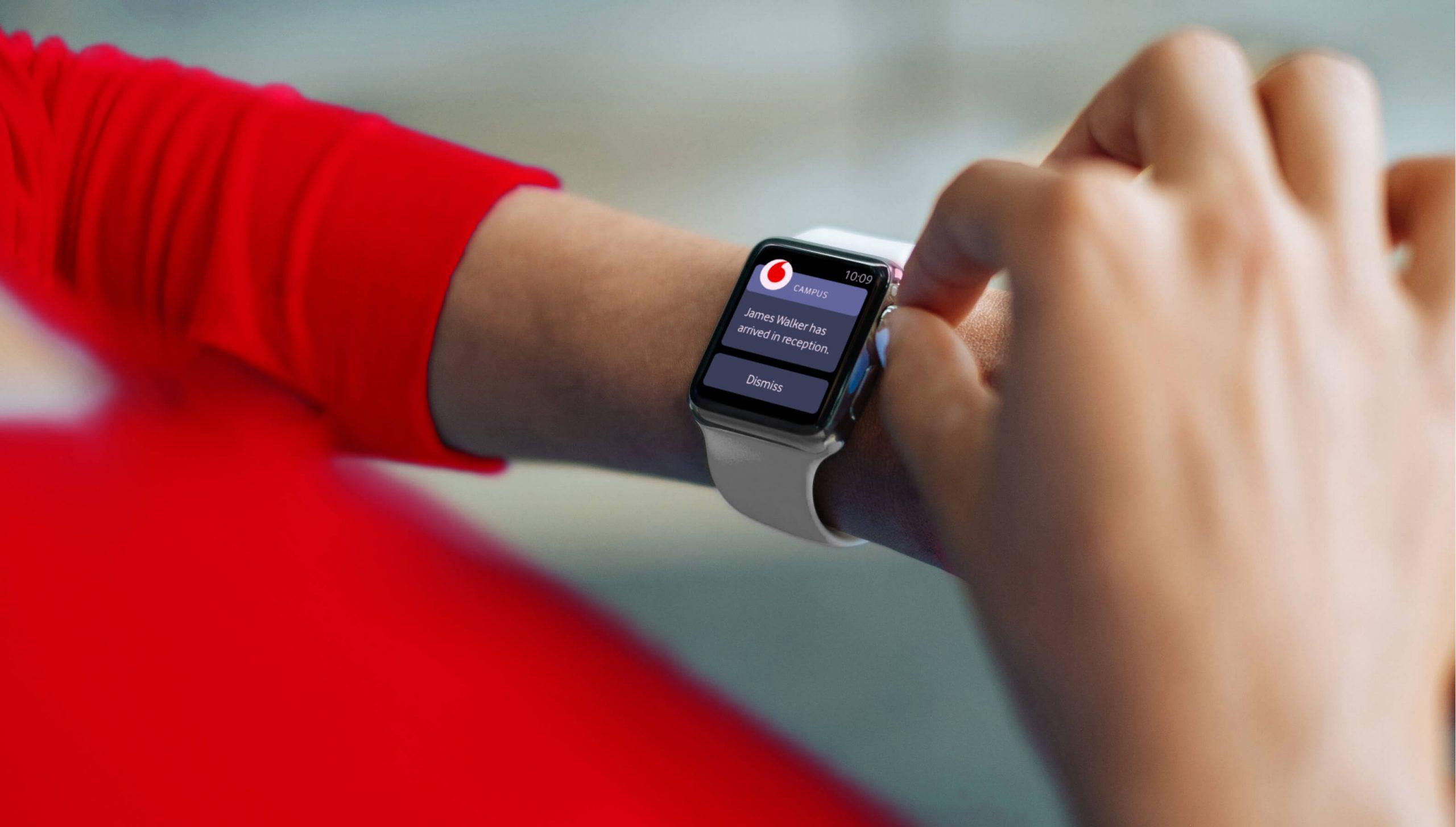 A person wearing a white smartwatch on their wrist receives a notification about donated blood being urgently needed, while touching the watch with their other hand.